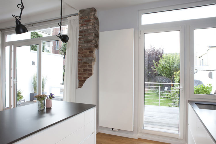 Offene Küche mit Wandheizkörper und Fensteranlage zur Terrasse in Neuss